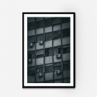 Black and blue photograph of a guy standing looking out of his apartment building