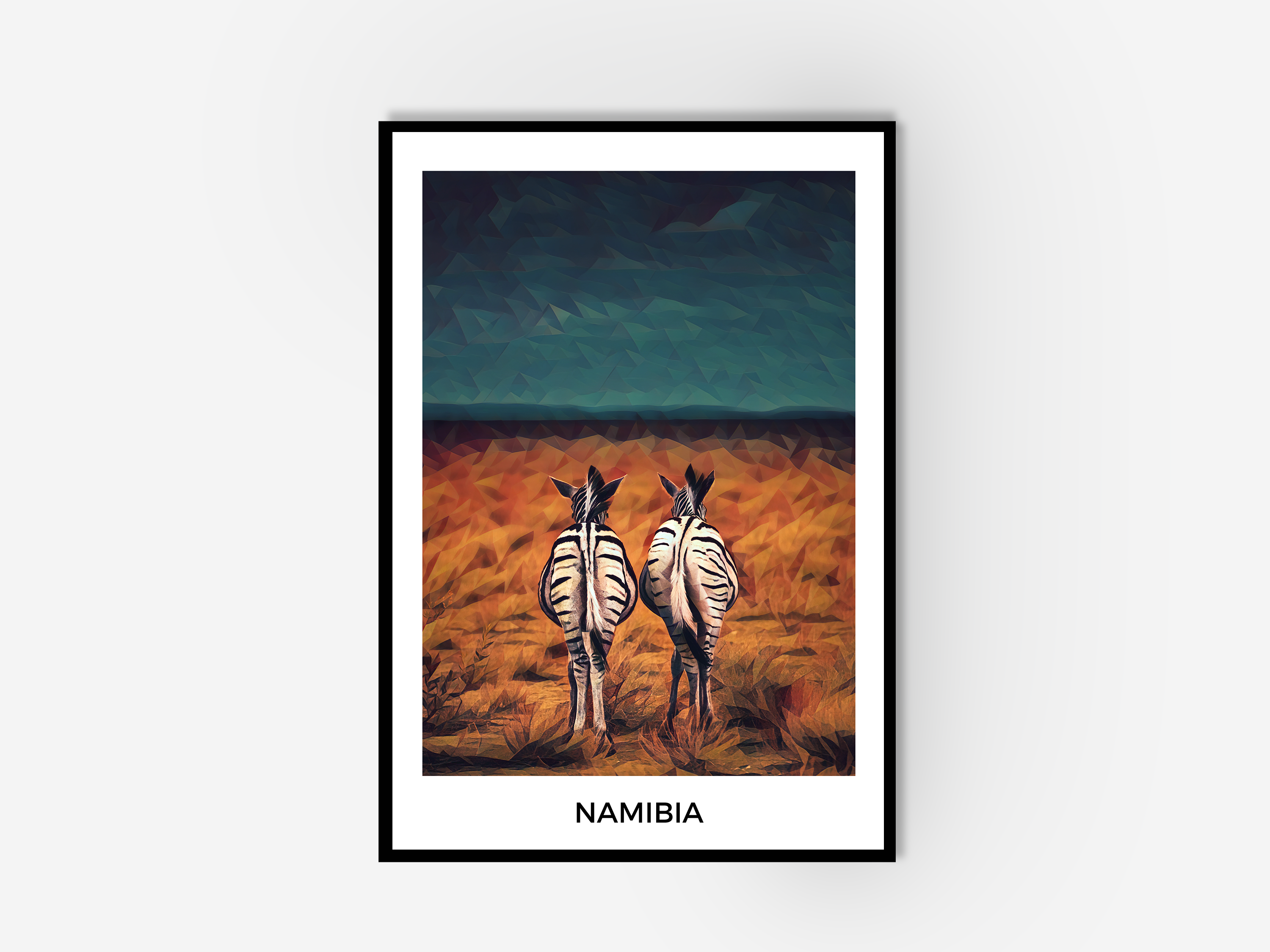 Framed wall art of two zebras standing in an orange field looking at a blue stormy sky. The framed art includes white border with text saying 'Namibia'