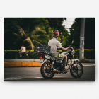 A man on a scooter with a raggea Jamaican hat