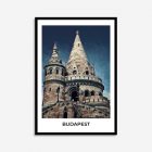 A framed print with white borders and wooden black frame. The print includes an old castle like architecture building.