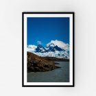 A framed photo of a mountain range under a clear blue sky.