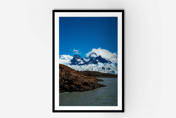 A framed photo of a mountain range under a clear blue sky.