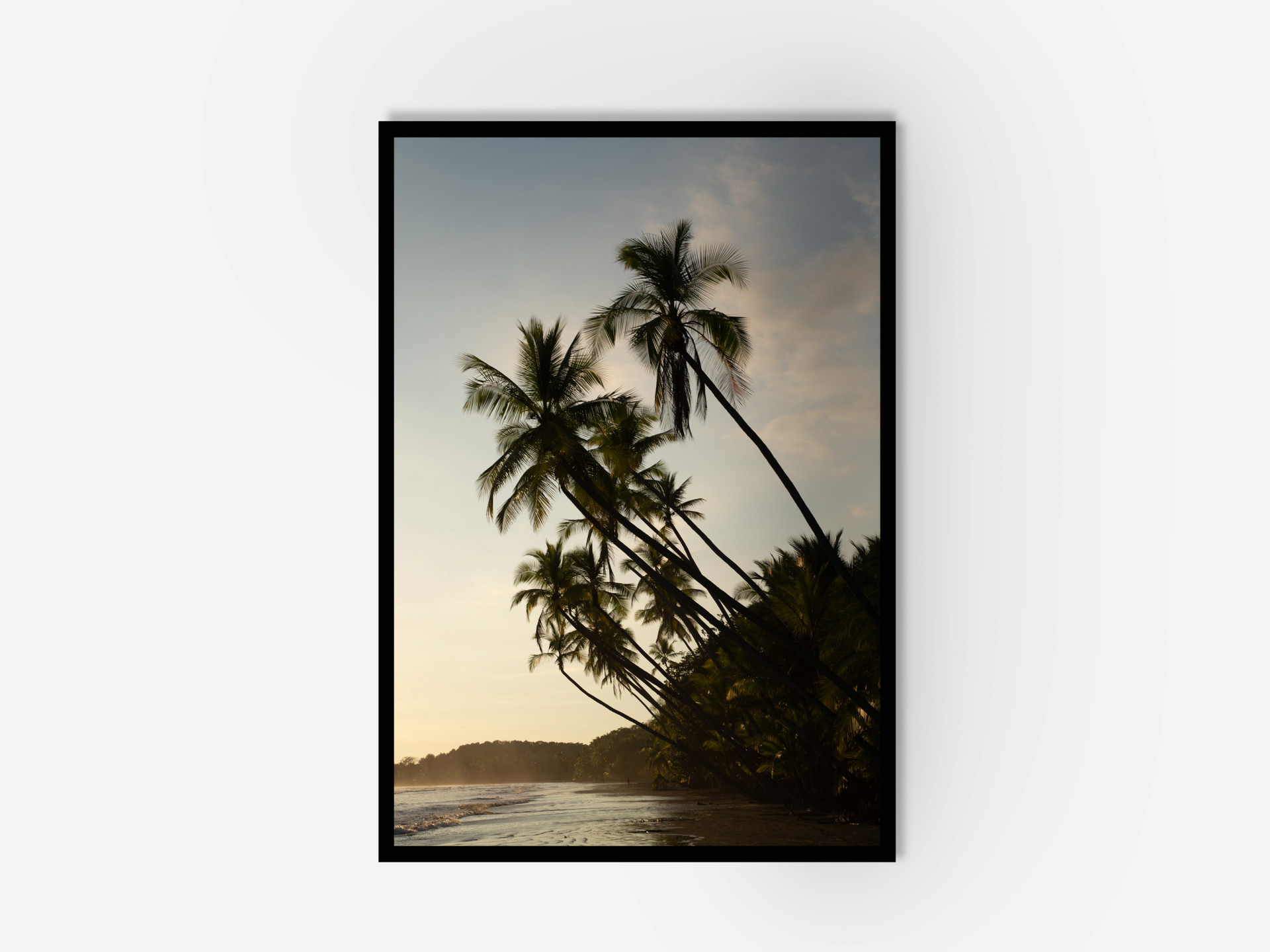 Beautiful sunset view of palm trees on the beach in a framed photo.