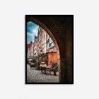 Archway in Gdansk, Poland, framing a vibrant row of colorful historic buildings beneath a cloudy sky, highlighting the city's charming old town architecture.