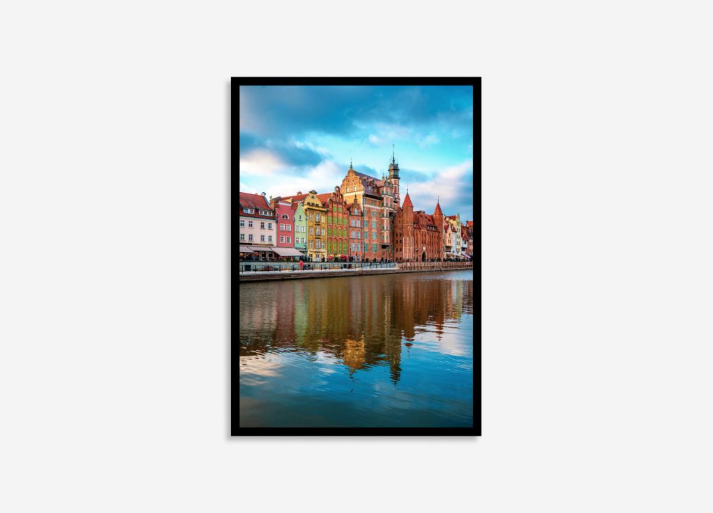 Gdansk, Poland colorful street buildings reflected vividly in the calm river, showcasing vibrant architecture and serene waterscape at sunset.