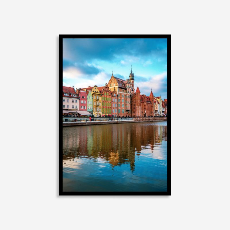 Gdansk, Poland colorful street buildings reflected vividly in the calm river, showcasing vibrant architecture and serene waterscape at sunset.