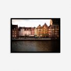 Historic colorful buildings in Gdansk, Poland, bathed in warm brown and orange sunset light, forming a lively and vibrant cityscape.