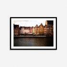 Colorful historic buildings in Gdansk, Poland, glowing with warm brown and orange hues as the sun sets, creating a vibrant cityscape.