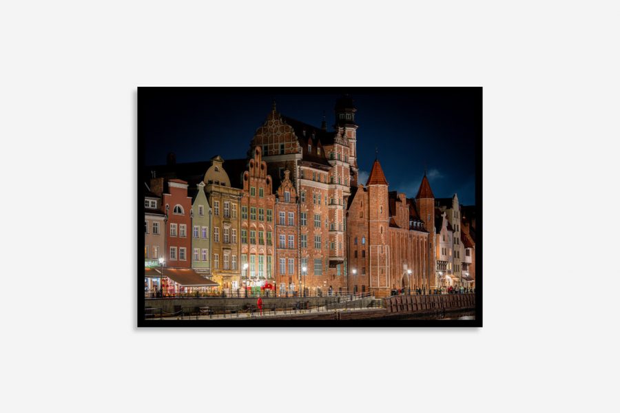 Gdansk buildings glowing at night with historic Gothic and Renaissance architecture, city lights, and reflections along the tranquil riverfront