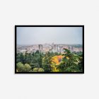 Madrid during a golden autumn day, with trees showing bright fall colors next to modern Spanish architecture. Full of autumnal colours with green at the forefront.