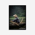 Vietnamese man rowing a boat, wearing a traditional conical hat on the wate