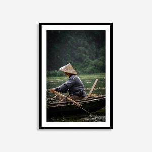 Vietnamese rower man wearing a traditional conical hat paddling on a river"